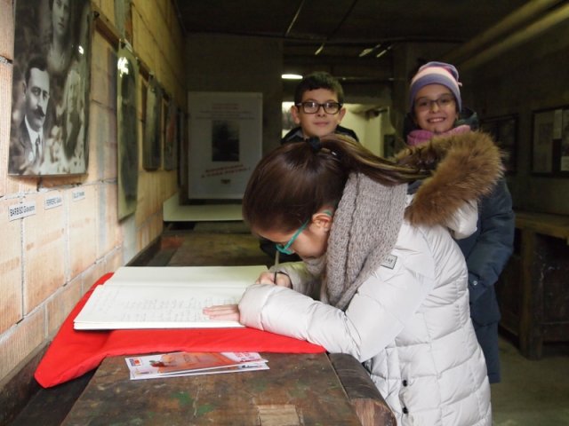 70- luigi e piero - i bambini firmano sul libro de le person dij partigian foto di franco brunetta-800x600